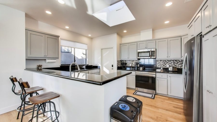 Modern, fully stocked kitchen with dishwasher, range, microwave, refrigerator, and Keurig coffee/tea maker