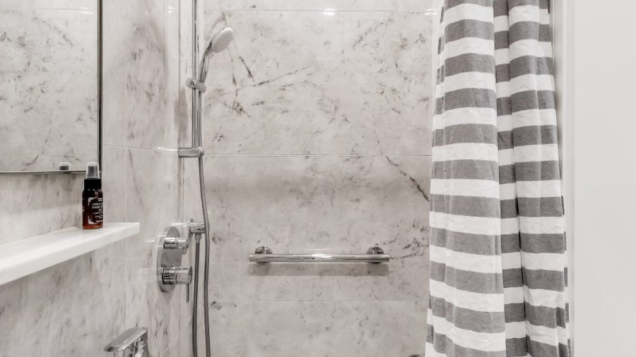 spacious shower stall with rainfall shower head and removable shower arm for a spa like shower.