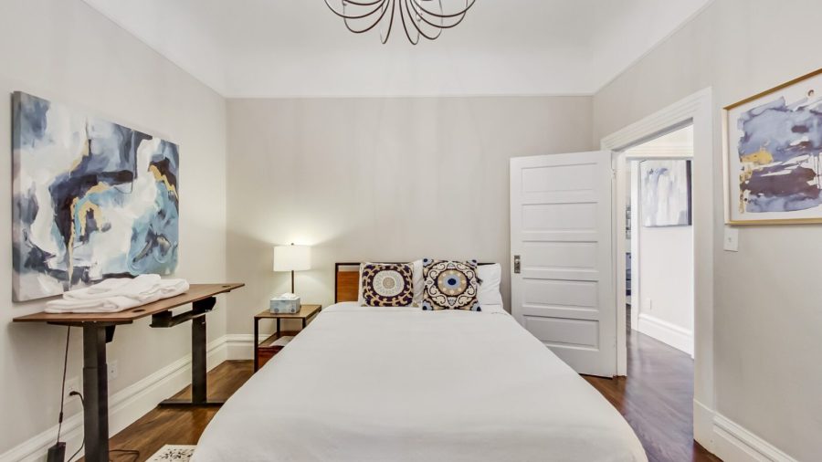 Main level bedroom has a queen bed, en suite bathroom and a standing desk