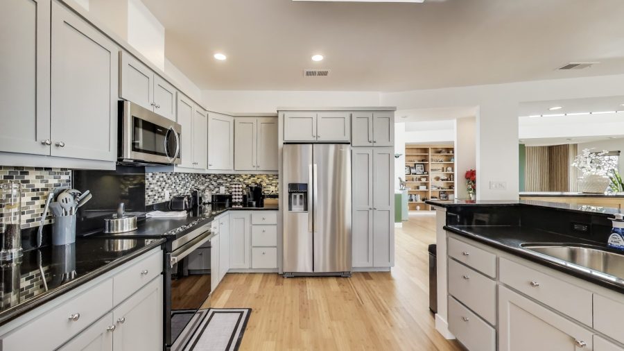 Modern, fully stocked kitchen with dishwasher, range, microwave, refrigerator, and Keurig coffee/tea maker