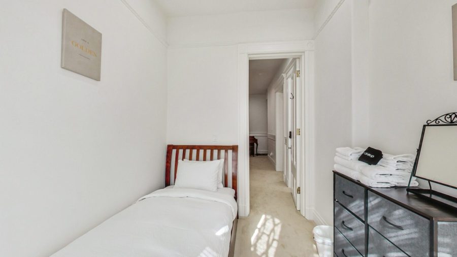 Bedroom 5 is cozy with a twin bed and a view onto Page street.