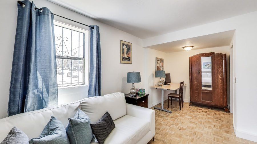 the large studio room has a bed, sofa, wardrobe and desk.