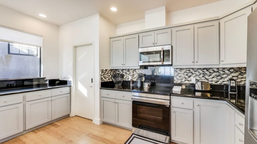 Modern, fully stocked kitchen with dishwasher, range, microwave, refrigerator, and Keurig coffee/tea maker