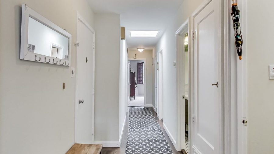 Entry door on the left and a shared bathroom on the right before continuing down the hallway to the bedrooms.  Across from the desk, the door with the tourism pamphlets is the door to the basement where you can find the laundry area and the exit to the shared backyard.