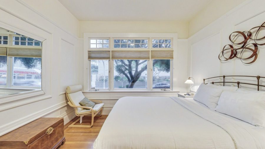 The bedroom with queen-sized bed looks out onto a lovely tree-lined street.