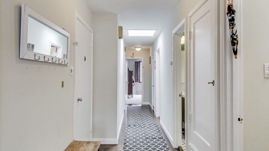 Entry door on the left and a shared bathroom on the right before continuing down the hallway to the bedrooms.  Across from the desk, the door with the tourism pamphlets is the door to the basement where you can find the laundry area and the exit to the shared backyard.