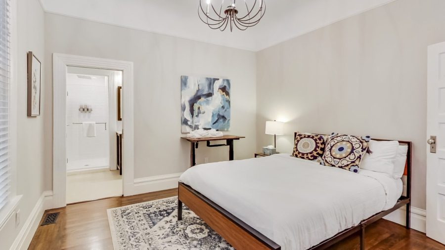 Main level bedroom has a queen bed, en suite bathroom and a standing desk