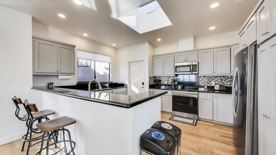 Modern, fully stocked kitchen with dishwasher, range, microwave, refrigerator, and Keurig coffee/tea maker