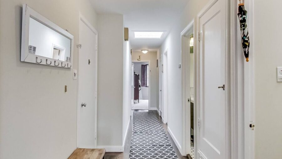 Entry door on the left and a shared bathroom on the right before continuing down the hallway to the bedrooms.  Across from the desk, the door with the tourism pamphlets is the door to the basement where you can find the laundry area and the exit to t