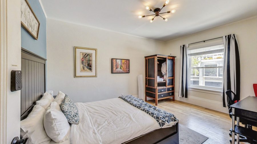 Blue room has a view onto noe street along with a wardrobe to unpack, a desk and a chair.
