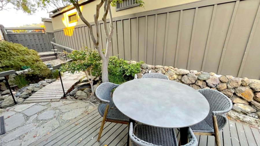 The front patio/deck is located in a secluded courtyard hidden away from street view and doubles as the main entrance to the home