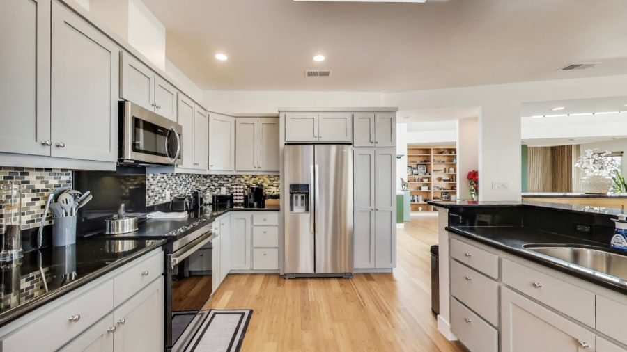 Modern, fully stocked kitchen with dishwasher, range, microwave, refrigerator, and Keurig coffee/tea maker