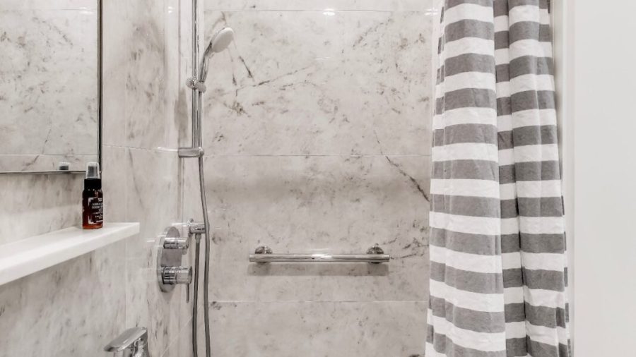 spacious shower stall with rainfall shower head and removable shower arm for a spa like shower.