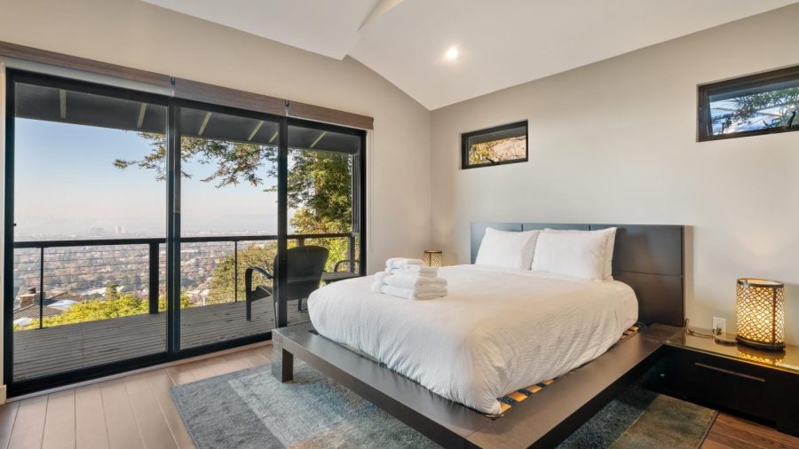 Upstairs bedroom with queen bed and access to upper deck with outstanding views