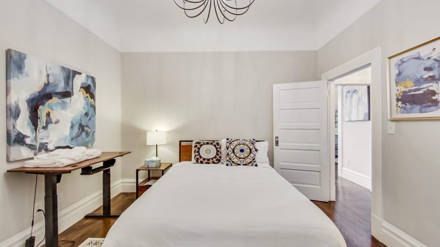 Main level bedroom has a queen bed, en suite bathroom and a standing desk