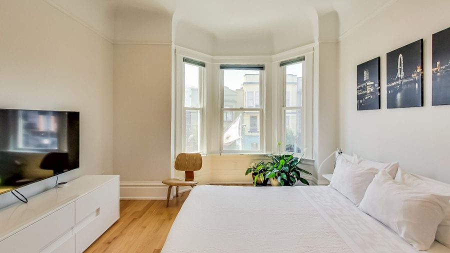 Large and bright bedroom with queen-sized bed, view overlooking Castro St. and 18th, TV with Dish Network and Netflix...