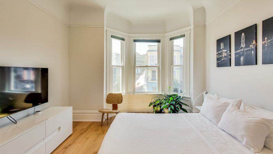 Large and bright bedroom with queen-sized bed, view overlooking Castro St. and 18th, TV with Dish Network and Netflix...