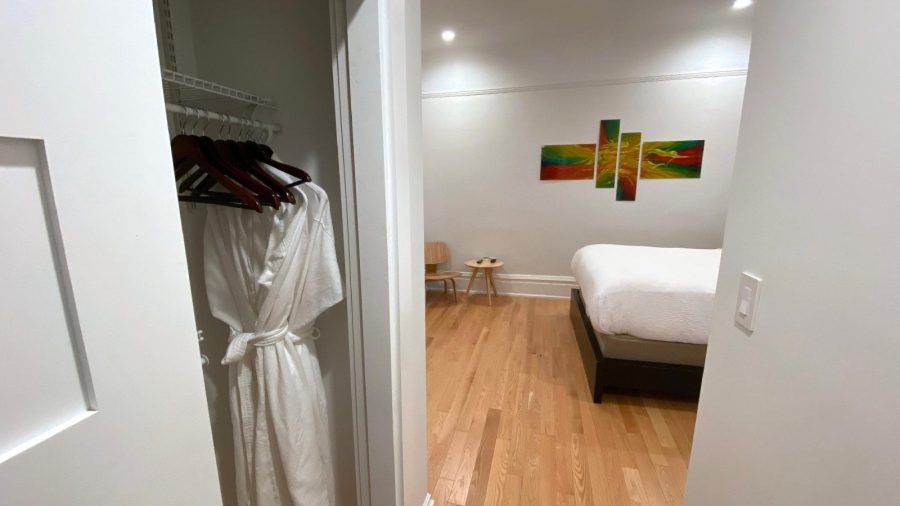 View of the Master Suite queen-sized bed from hallway to en suite full bath. Plenty of clothing storage on the left side of the hallway...