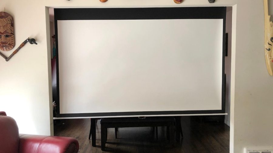 Living room with Projector and Apple TV, just pull the screen down from the top of the door frame to obscure the dining room and show the TV...