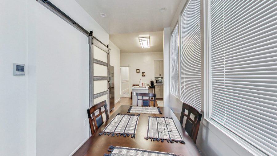 Dining table off of the kitchen next to the door out to laundry and down to garden.