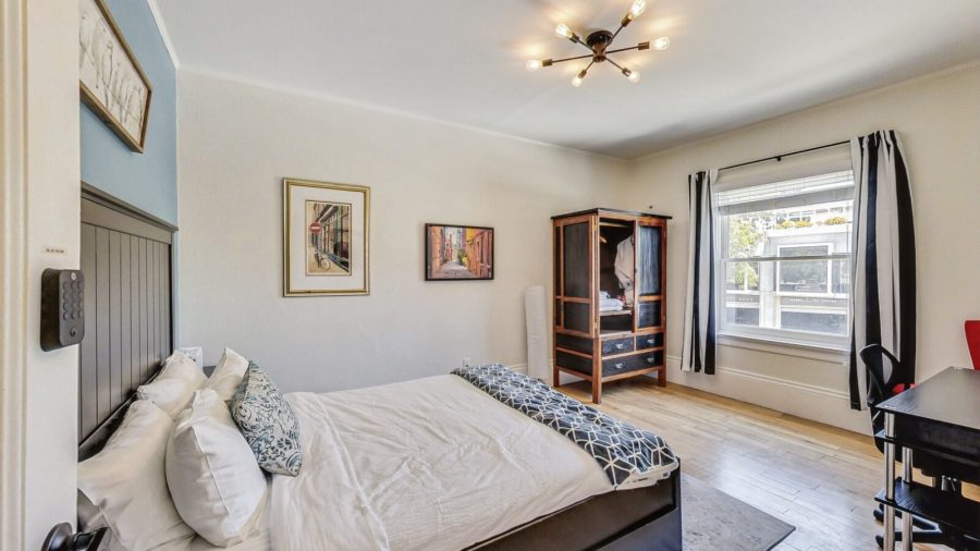 Blue room has a view onto Noe street along with a wardrobe to unpack, a desk and a chair.