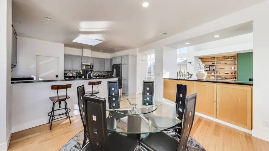 The dining room seats six guests. There is additional bar stool seating for two adjacent to the dining table with views into the open kitchen