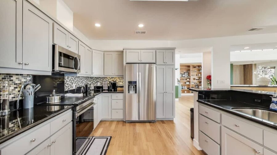 Modern, fully stocked kitchen with dishwasher, range, microwave, refrigerator, and Keurig coffee/tea maker