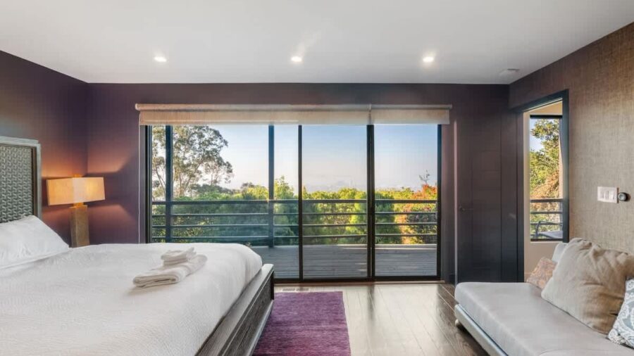 Equally spacious bedroom, to the left after descending the stairs, with en suite bathroom, access to lower deck, and access to small kids bedroom with twin-over-full bunk bed sleeping arrangement.  This room features motorized window shades, please u