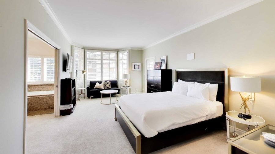 Large master bedroom with queen bed, sofa and private balcony